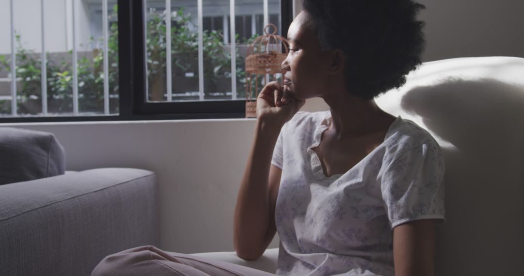 Pensive Woman Sitting at Home Near Window - Free Images, Stock Photos and Pictures on Pikwizard.com