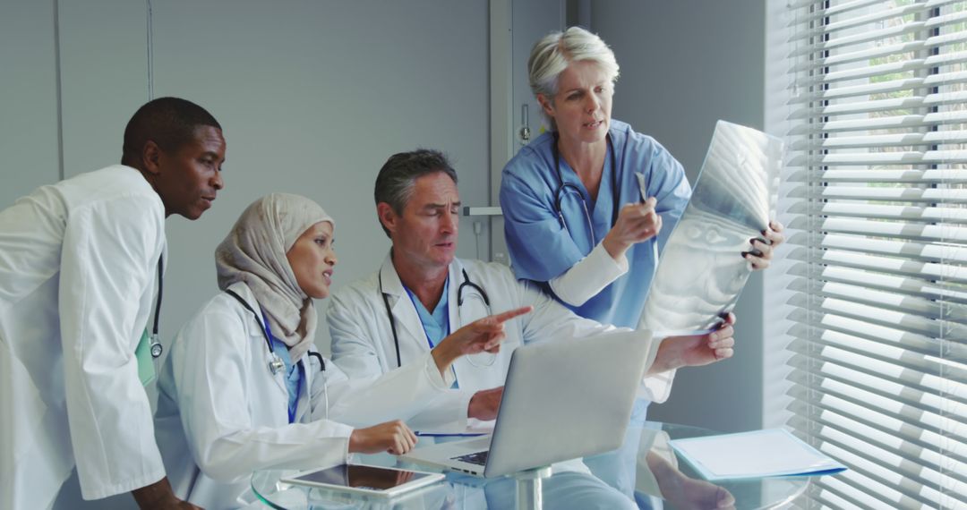 Diverse Medical Team Discusses Patient X-Ray in Hospital Office - Free Images, Stock Photos and Pictures on Pikwizard.com