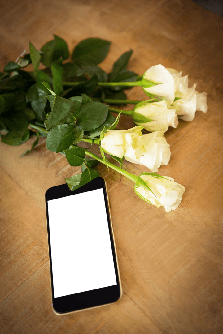 High Angle Mobile Phone with White Roses on Transparent Table