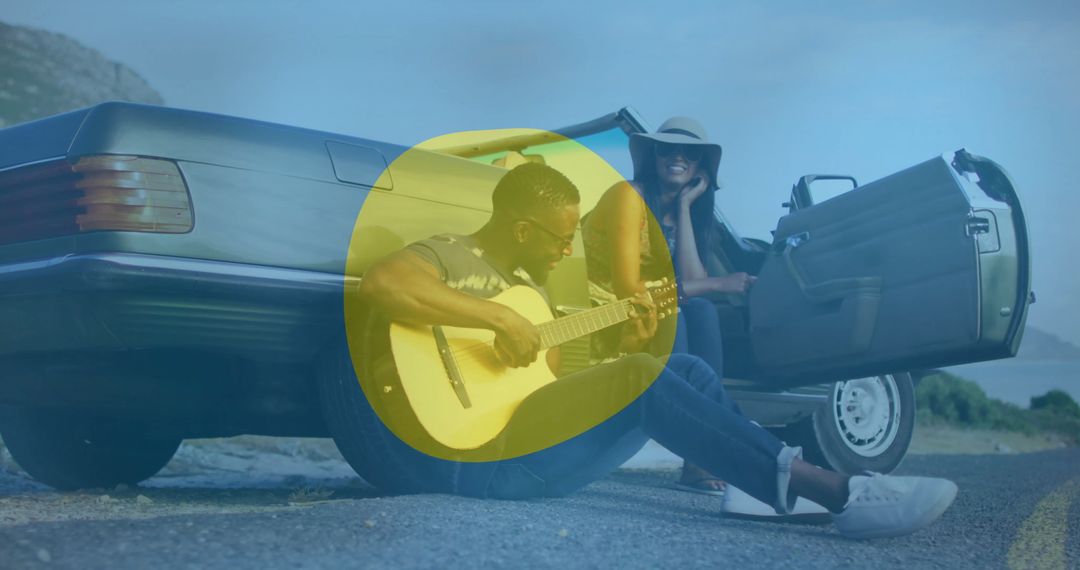 Man Playing Guitar by Convertible on Scenic Coastal Road