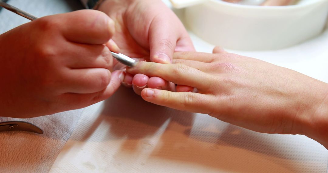 Nail Technician Manicuring Customer in Salon