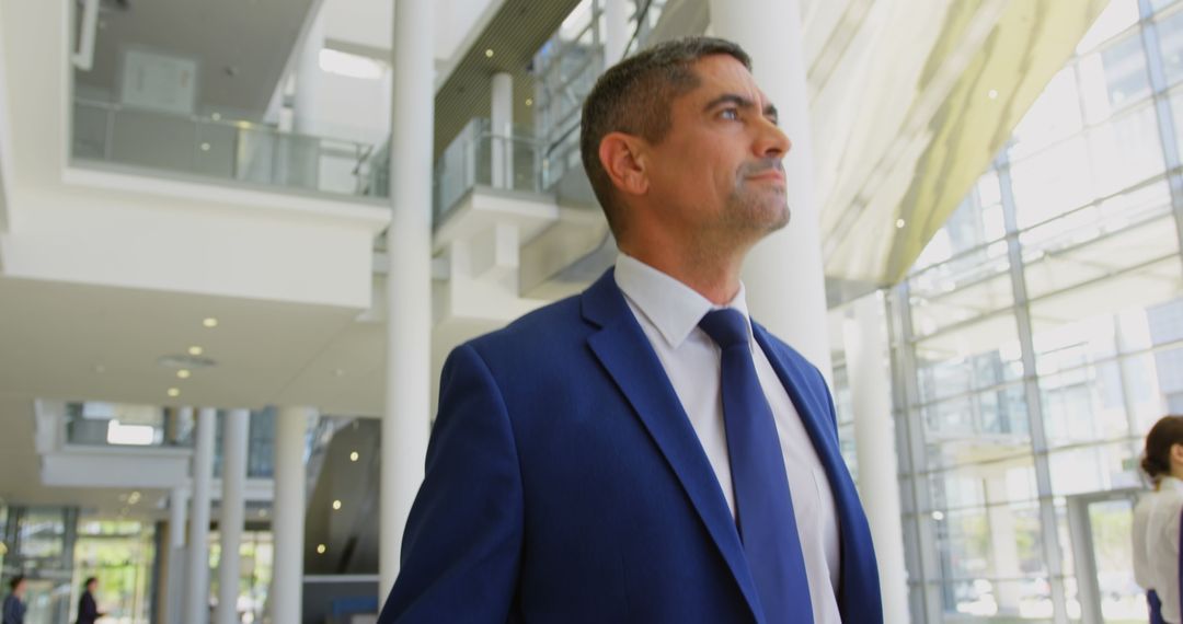 Confident Businessman Walking in Modern Office Lobby