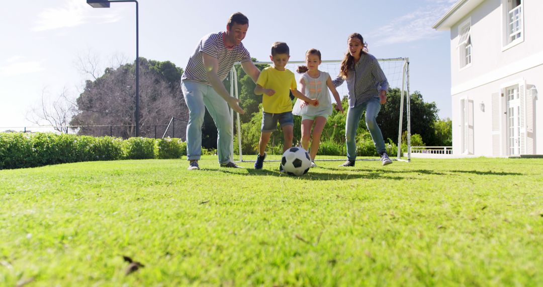 Happy Family Playing Soccer Together in Backyard on Sunny Day - Free Images, Stock Photos and Pictures on Pikwizard.com