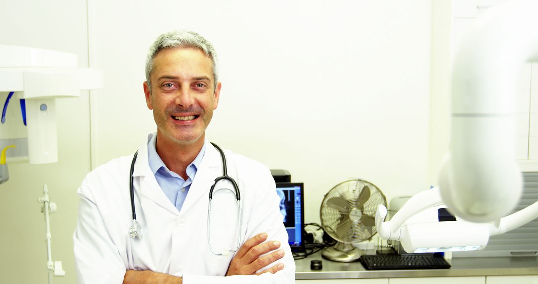 Smiling Male Doctor in Medical Office with Equipment - Free Images, Stock Photos and Pictures on Pikwizard.com