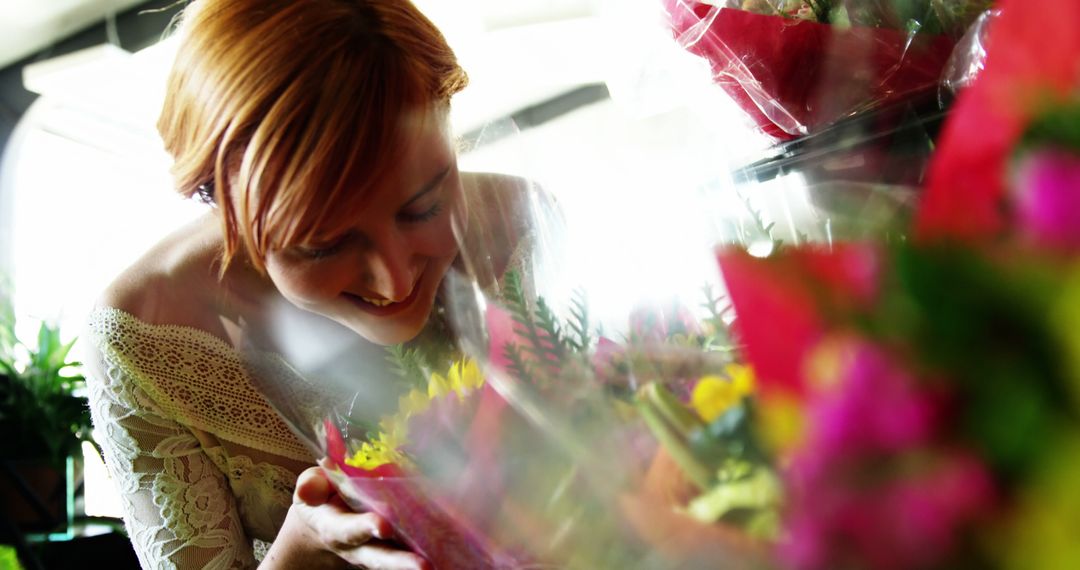 Smiling Woman with Red Hair Enjoying Fresh Flowers in Market - Free Images, Stock Photos and Pictures on Pikwizard.com