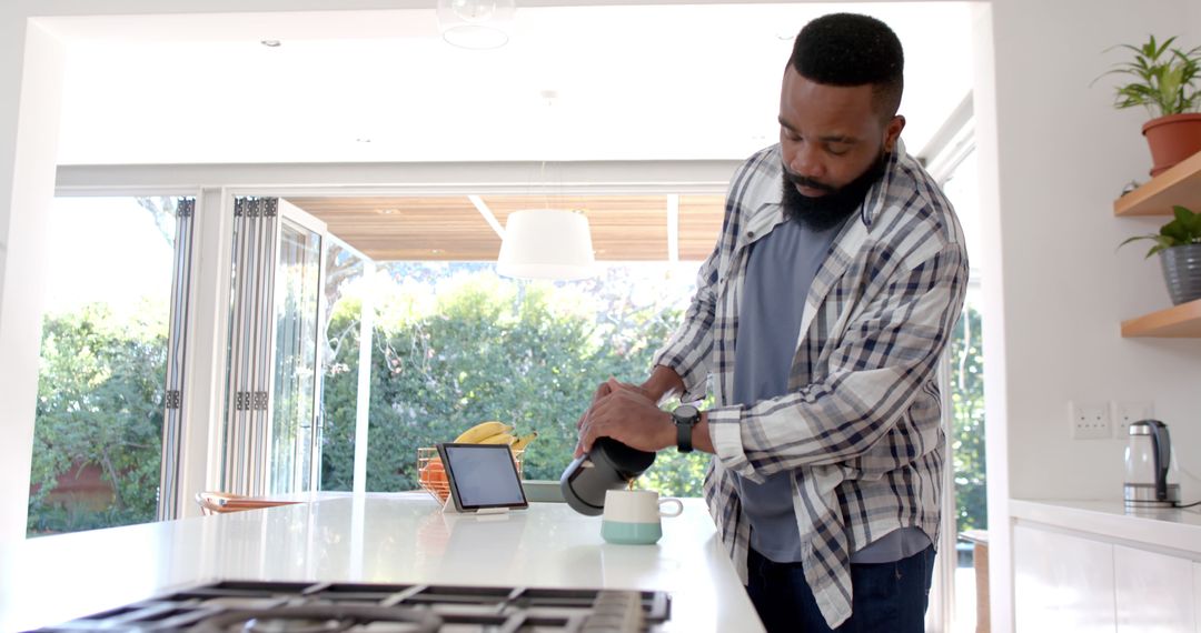 Man Preparing Coffee in Modern Kitchen with Natural Light - Free Images, Stock Photos and Pictures on Pikwizard.com