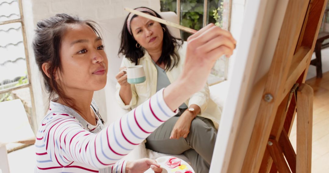 Asian Art Student Painting in Studio with Mentor