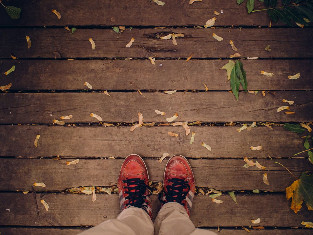 Top View of Feet in Red Shoes on Wooden Deck with Leaves - Free Images, Stock Photos and Pictures on Pikwizard.com