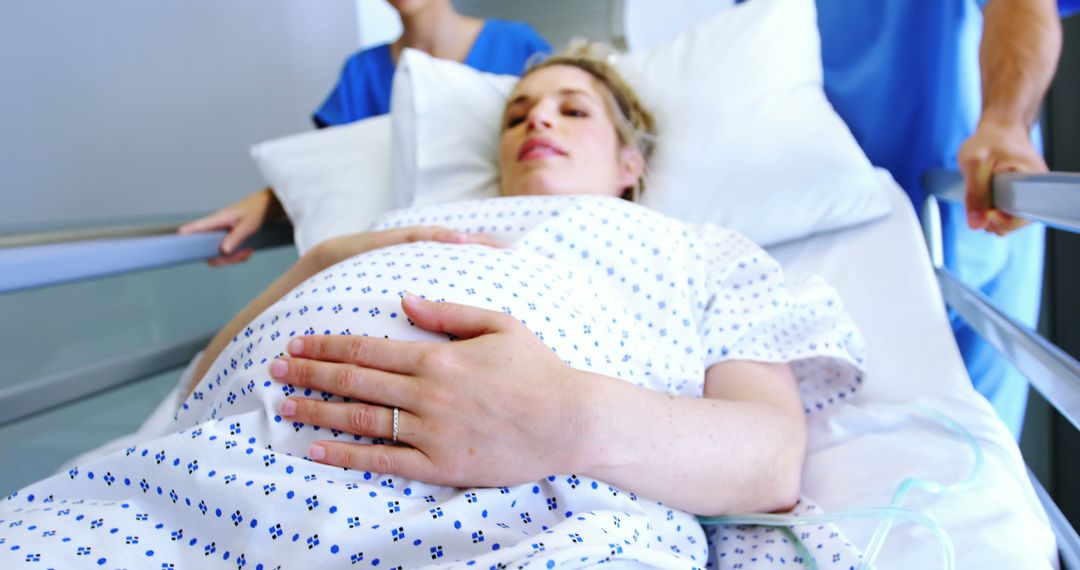 Pregnant Woman in Hospital Bed During Labor with Medical Staff Assisting - Free Images, Stock Photos and Pictures on Pikwizard.com