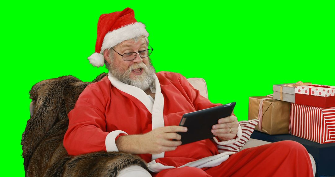 Santa Claus Using Digital Tablet During Christmas Time - Free Images, Stock Photos and Pictures on Pikwizard.com