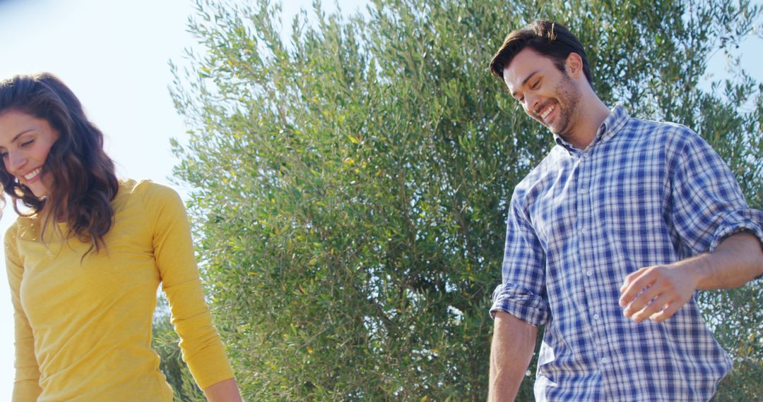 Happy Couple Enjoying Walk in Olive Grove