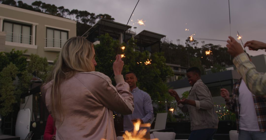 Diverse Colleagues Celebrating with Sparklers on Rooftop - Free Images, Stock Photos and Pictures on Pikwizard.com