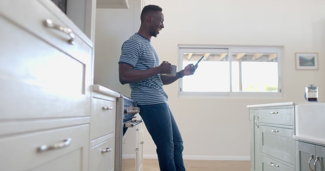 Man Enjoying Coffee Break in Modern Kitchen While Using Smartphone - Free Images, Stock Photos and Pictures on Pikwizard.com