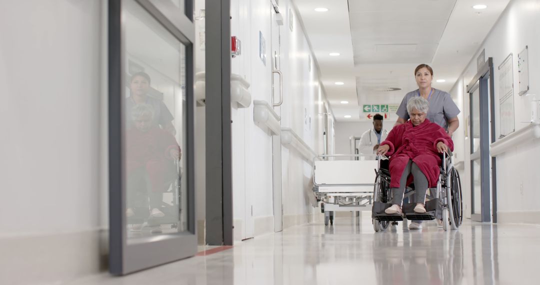 Nurse Caring for Elderly Patient in Wheelchair in Hospital Hallway - Free Images, Stock Photos and Pictures on Pikwizard.com