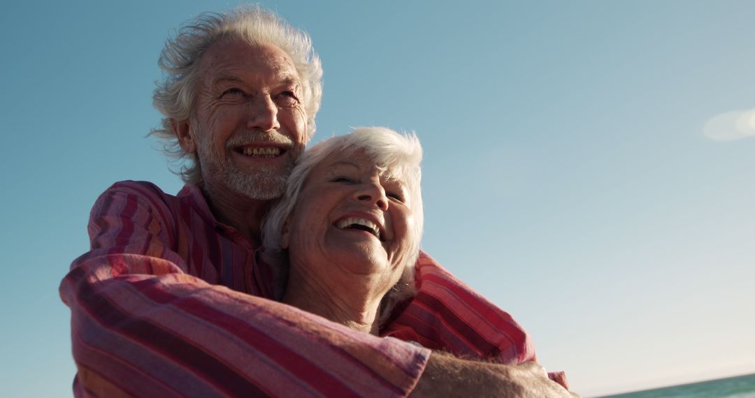 Happy Senior Couple Hugging Outdoors Against Blue Sky - Free Images, Stock Photos and Pictures on Pikwizard.com