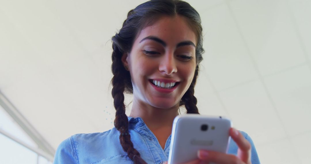 Smiling Young Woman Engaging with Smartphone Technology