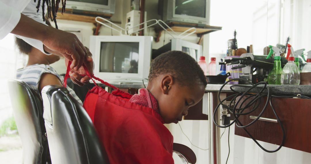 Child Getting Haircut in Barber Shop with Vintage TV Monitors - Free Images, Stock Photos and Pictures on Pikwizard.com