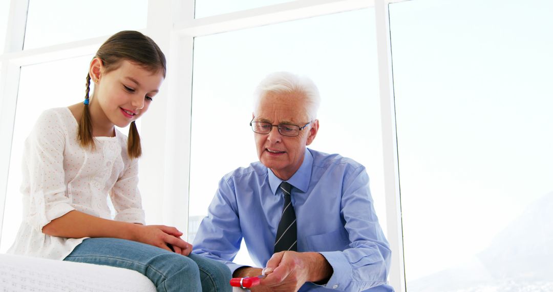 Grandfather Helping Granddaughter with Toy Inside Bright Room - Free Images, Stock Photos and Pictures on Pikwizard.com