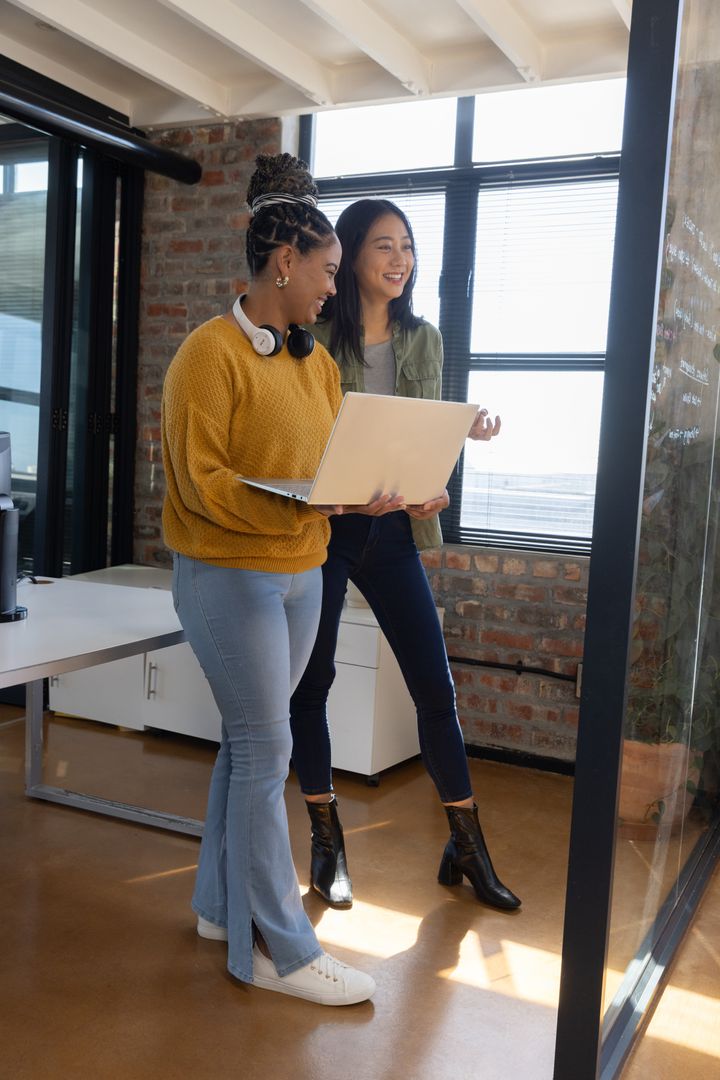 Diverse Female Coworkers in Modern Office Collaborating on Project