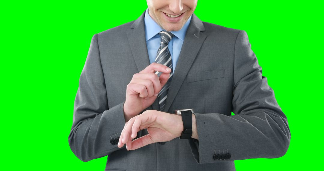 Businessman Checking Smartwatch and Smiling Against Green Screen - Free Images, Stock Photos and Pictures on Pikwizard.com