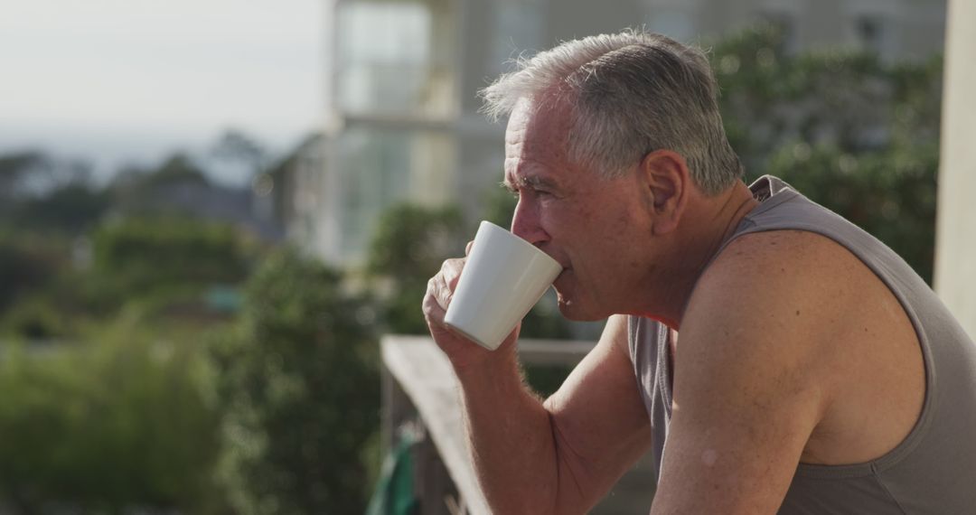 Senior Man Enjoying Coffee on Sunny Balcony - Free Images, Stock Photos and Pictures on Pikwizard.com