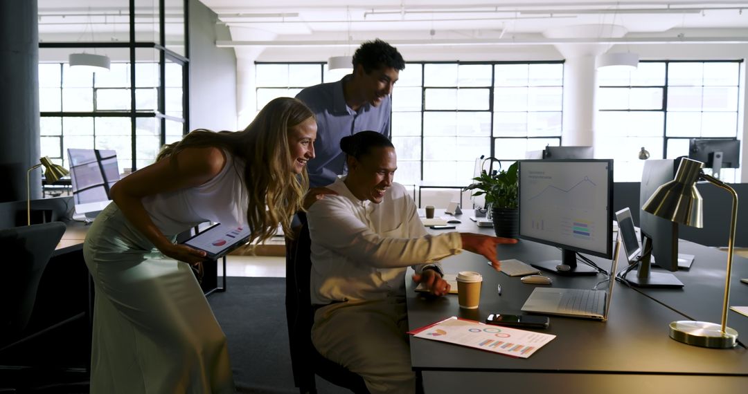 Colleagues Celebrating Office Success with Data Analysis