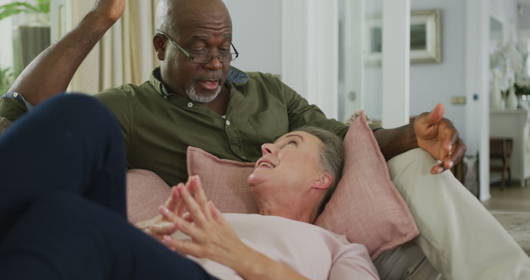 Senior Couple Relaxing and Chatting on Sofa at Home