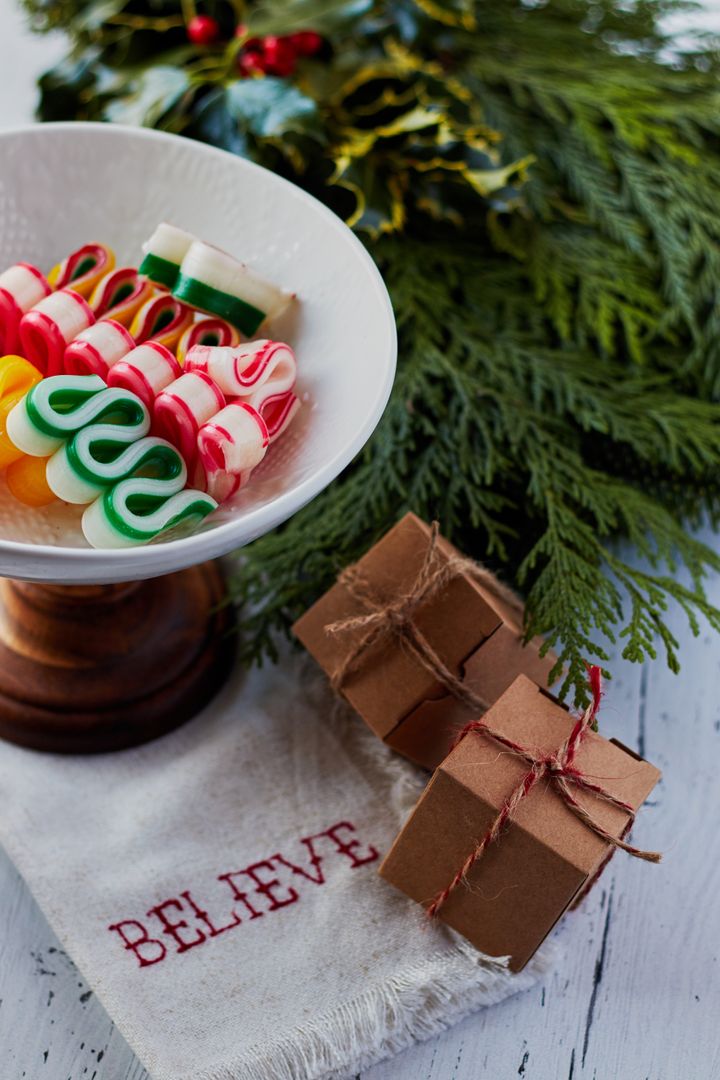 Celebrating Holiday Cheer with Candy Canes and Rustic Gift Boxes on Evergreen Tabletop