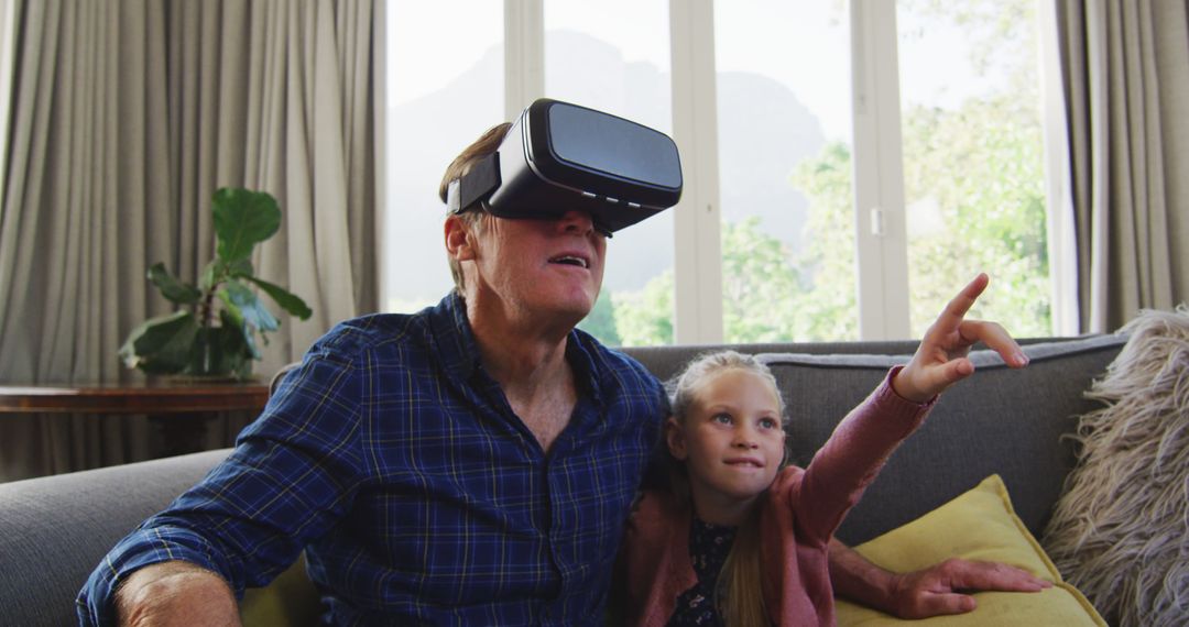 Grandfather and Granddaughter Exploring Virtual Reality Together at Home - Free Images, Stock Photos and Pictures on Pikwizard.com