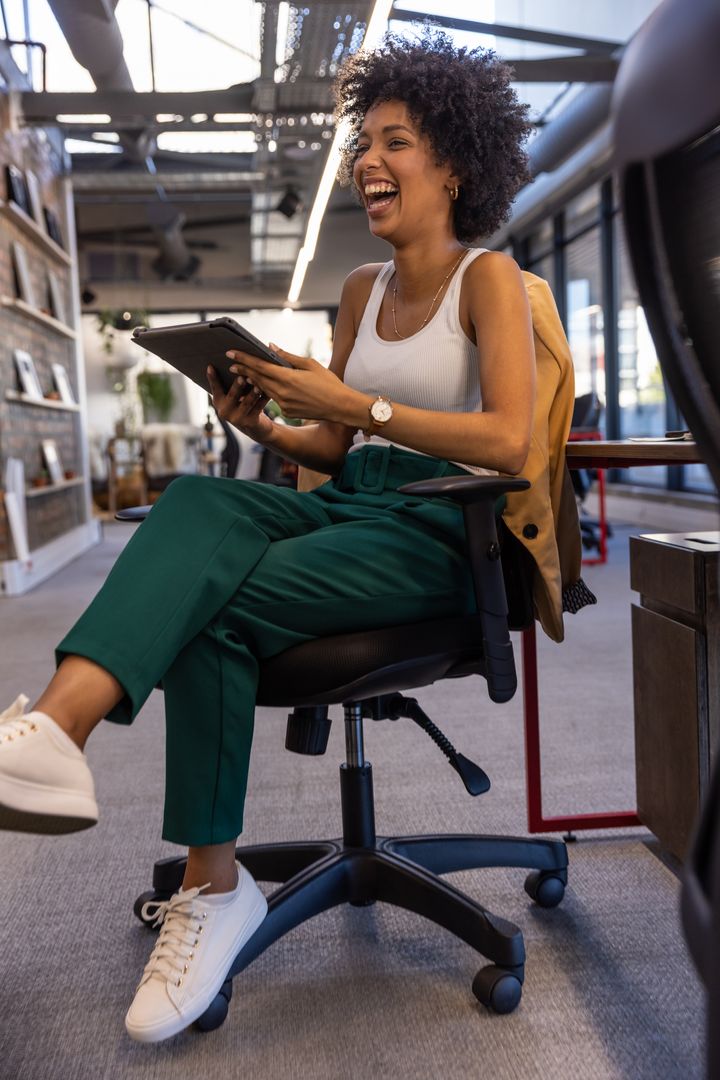 Joyful Professional Using Tablet in Modern Coworking Space