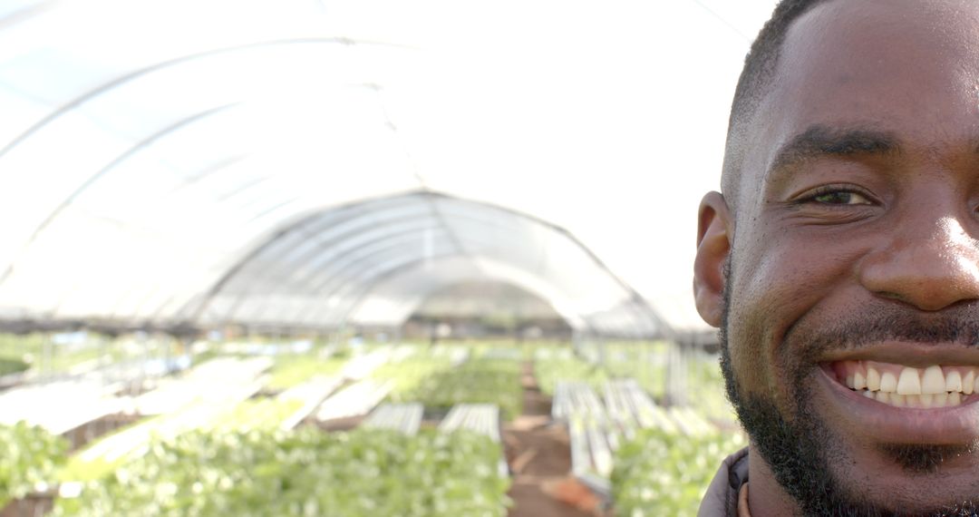 Smiling Man in Hydroponic Farm Reflecting Sustainable Agriculture Practices