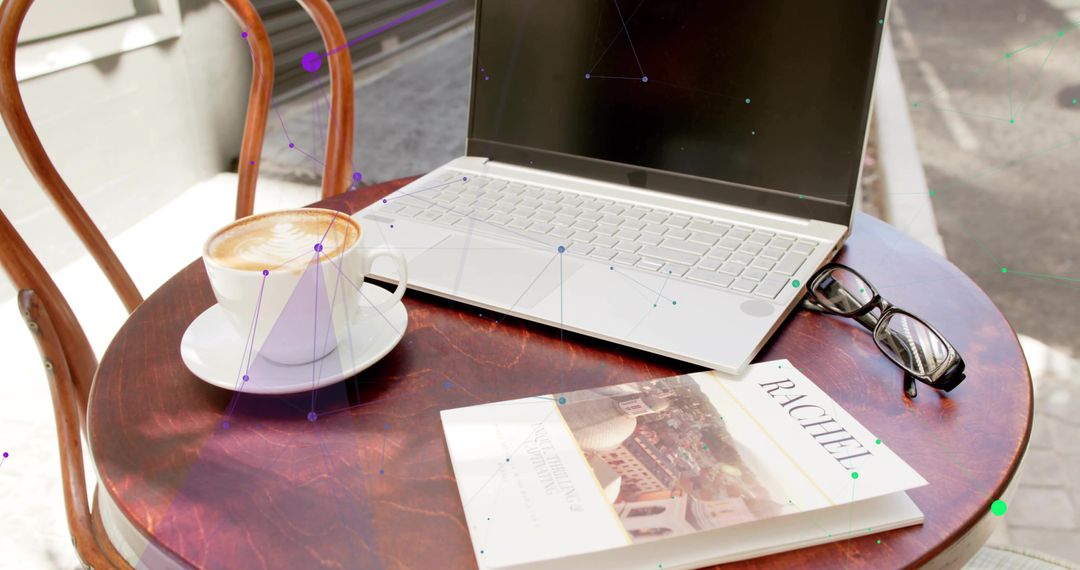 Outdoor Laptop Workspace at Café with Coffee and Travel Guide