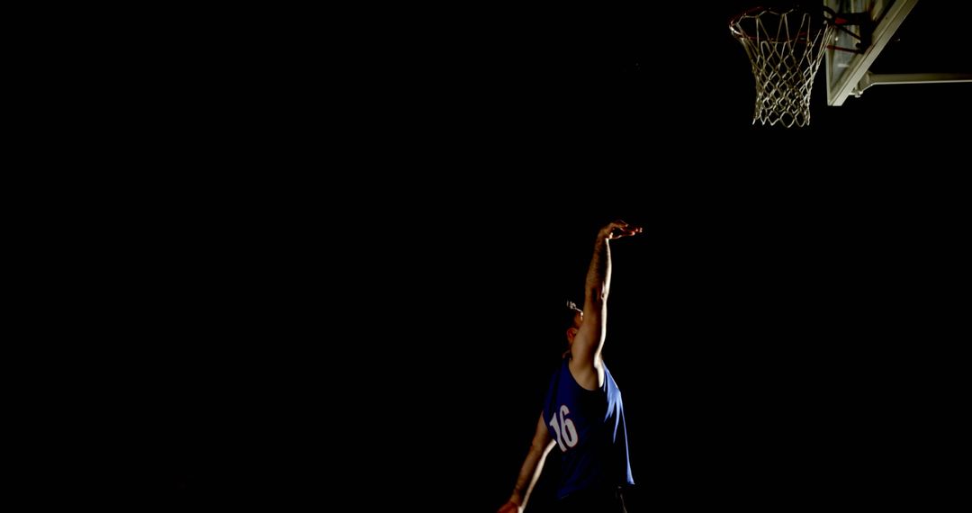 Basketball Player Practicing in Low Light Conditions with Focus and Precision