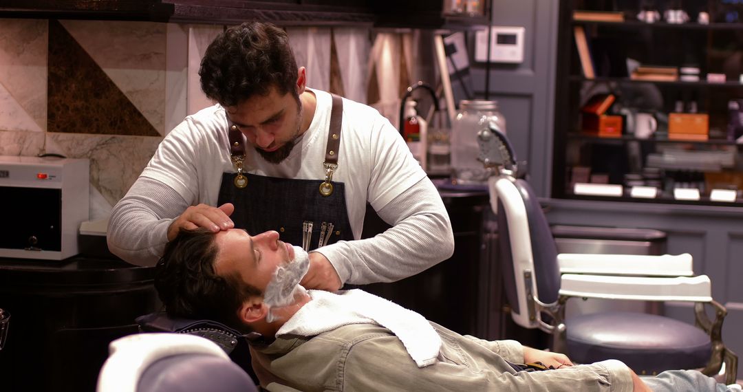 Barber Giving Customer Close Shave in Traditional Barbershop - Free Images, Stock Photos and Pictures on Pikwizard.com