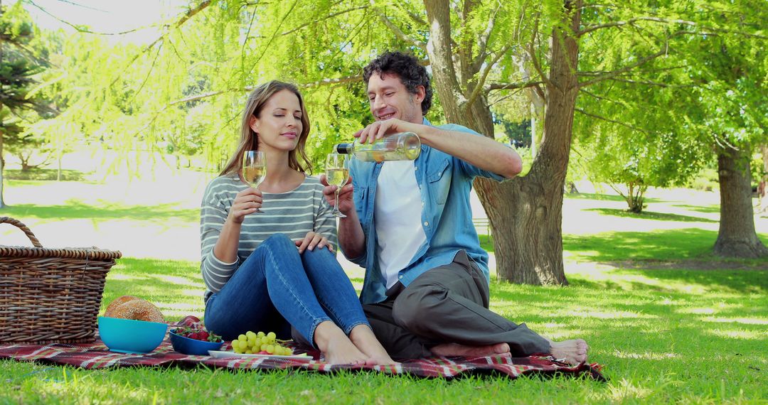 Couple Enjoying Outdoor Picnic with Wine Under Trees - Free Images, Stock Photos and Pictures on Pikwizard.com