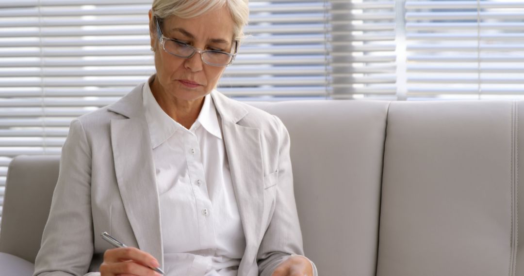 Mature Businesswoman Analyzing Documents at Modern Office - Free Images, Stock Photos and Pictures on Pikwizard.com