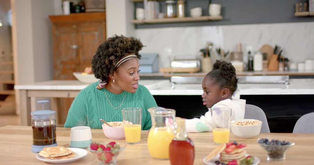 Happy African American Mother and Daughter Enjoying Breakfast Together at Home - Free Images, Stock Photos and Pictures on Pikwizard.com