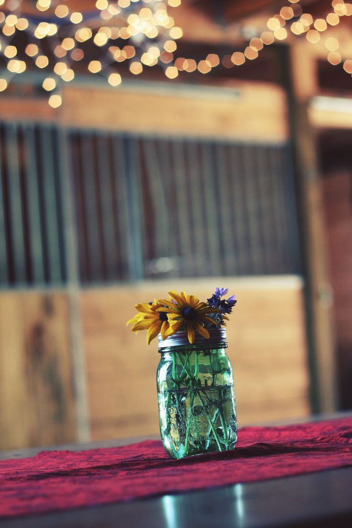 Rustic Mason Jar Centerpiece with Wildflowers in Barn Setting