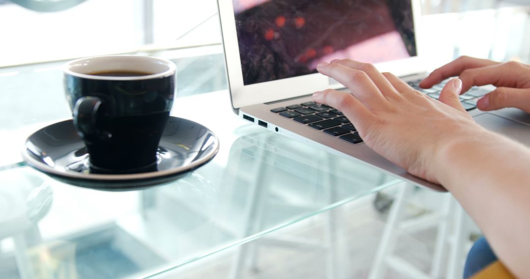 Person Typing on Laptop with Coffee Cup on Glass Table - Free Images, Stock Photos and Pictures on Pikwizard.com