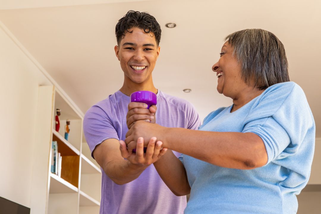 Hispanic Instructor Supporting Senior with Purple Dumbbell at Home