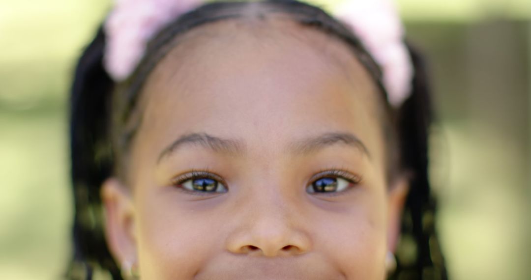 Joyful African American Girl with Hair Bows in Sunny Garden - Free Images, Stock Photos and Pictures on Pikwizard.com