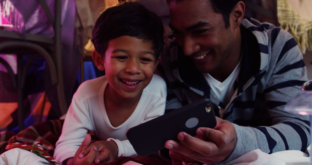 Father and Son Smiling While Watching Smartphone Together - Free Images, Stock Photos and Pictures on Pikwizard.com