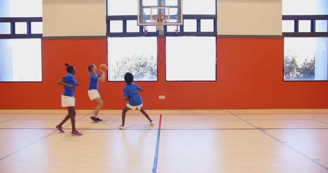 Female Child Athletes Practicing Basketball in Gymnasium