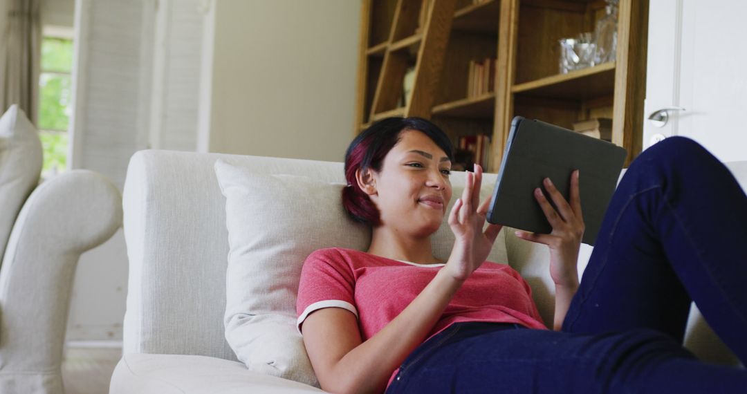 Young Woman Relaxing on Couch Using Tablet at Home - Free Images, Stock Photos and Pictures on Pikwizard.com