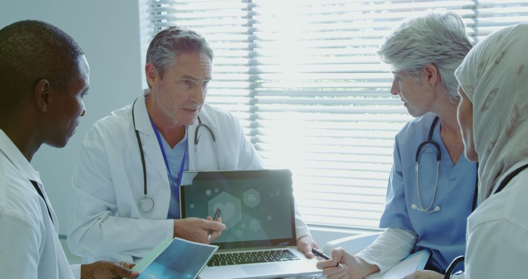 Multicultural Medical Team Collaborating with Laptop in Modern Clinic