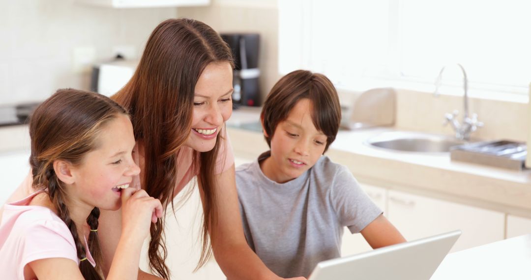 Smiling Mother Helping Two Children with Online Learning in Kitchen - Free Images, Stock Photos and Pictures on Pikwizard.com