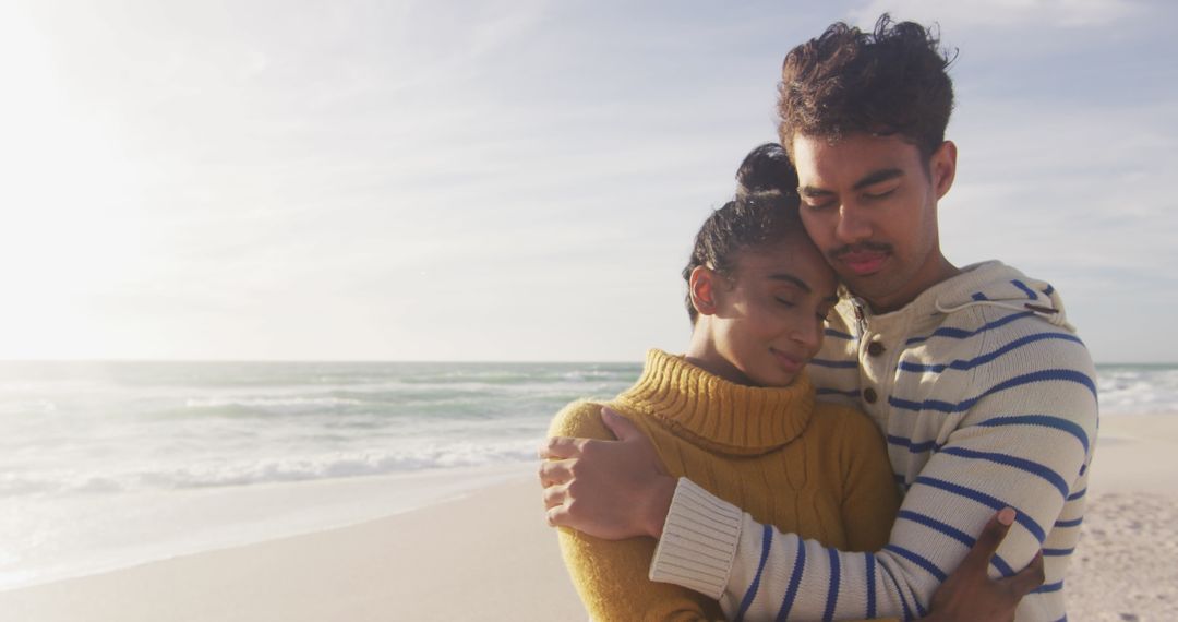 Hispanic Couple Embracing on Sunlit Beach