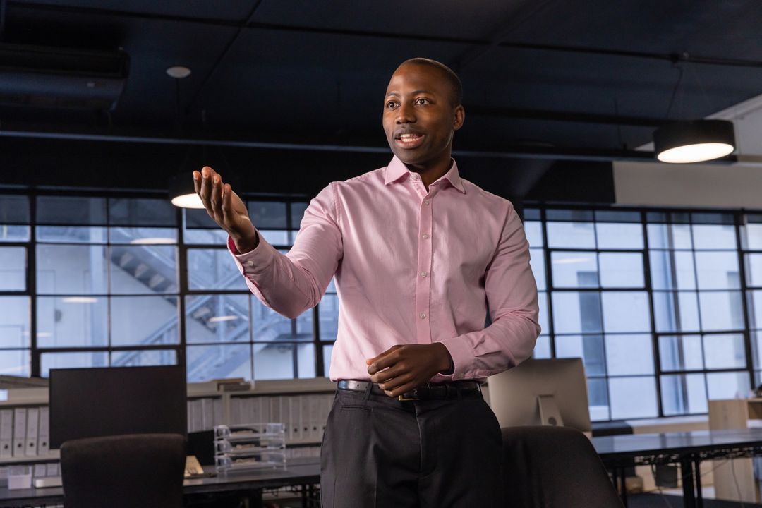 Confident Professional Gesturing in Modern Open-Plan Office