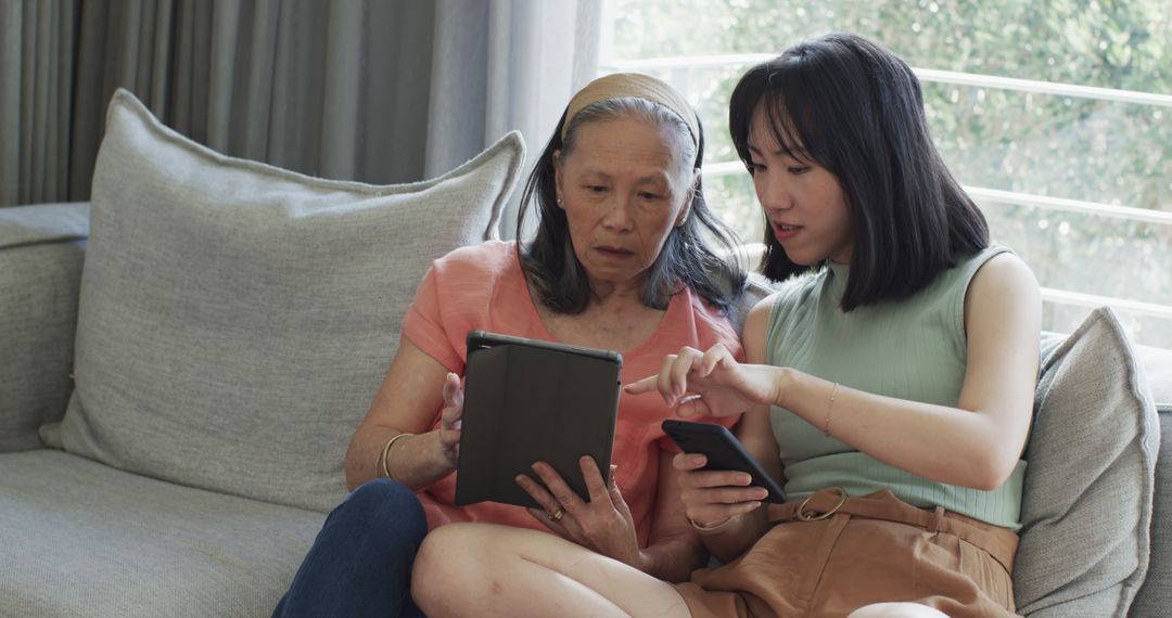 Multigenerational Asian Family Sharing Tech Devices at Home