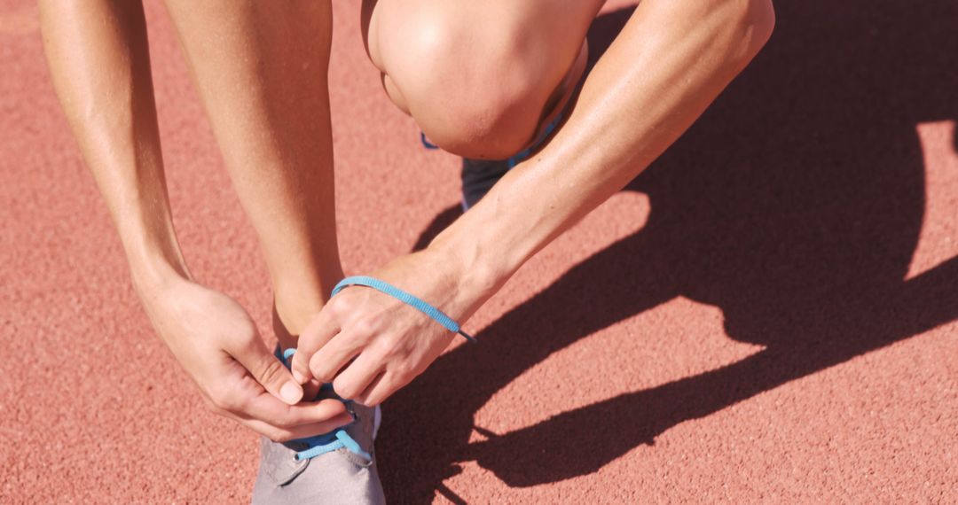 Athlete Tightening Shoelace on Running Track - Free Images, Stock Photos and Pictures on Pikwizard.com